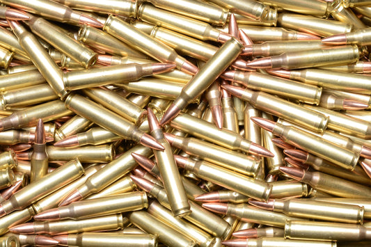 A pile of .223 caliber rifle ammunition rounds with brass casing.